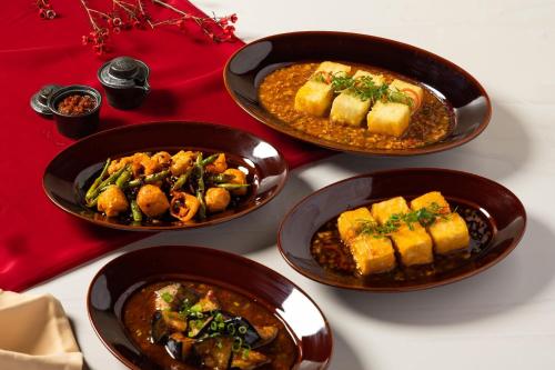 a table with four bowls of food on it at Chiang Mai Marriott Hotel in Chiang Mai