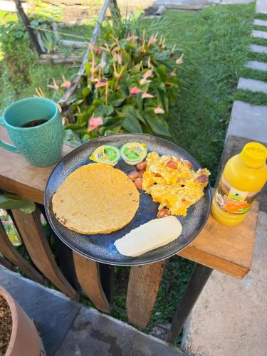 a plate of breakfast food and a pancake on a table at Ecoedén glamping in Guatapé
