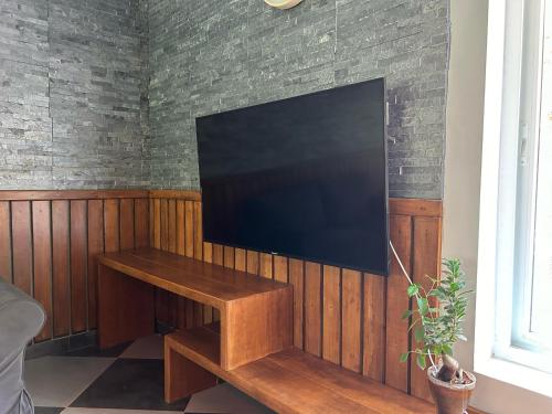 a flat screen tv hanging on a wall at Kayyath Valley Munnar - Luxury 4BHK Hillside Sanctuary in Anachal