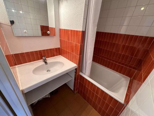 une salle de bain avec un lavabo, un miroir et une baignoire dans l'établissement Studio-cabine 4 pers, plage à 200m, parking privatif - FR-1-731-104, au Grau-du-Roi