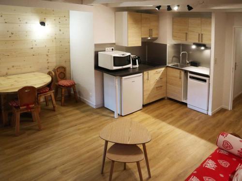 une petite cuisine avec une table et un micro-ondes dans l'établissement Grand studio rénové 4 pers, centre station, départ skis aux pieds - FR-1-322-640, aux Orres