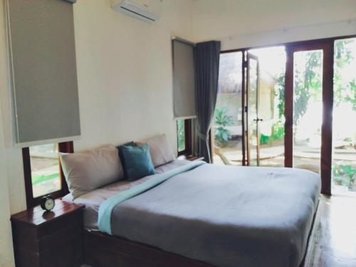 a bedroom with a bed and a large window at Villa Allure Koh Mak in Ko Mak