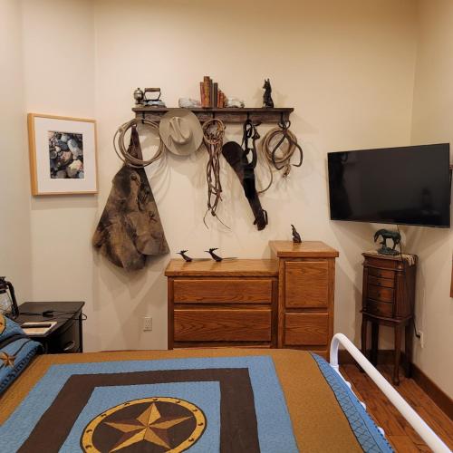 a bedroom with a tv and a bed with a dresser at Kings River Reflections in Sanger