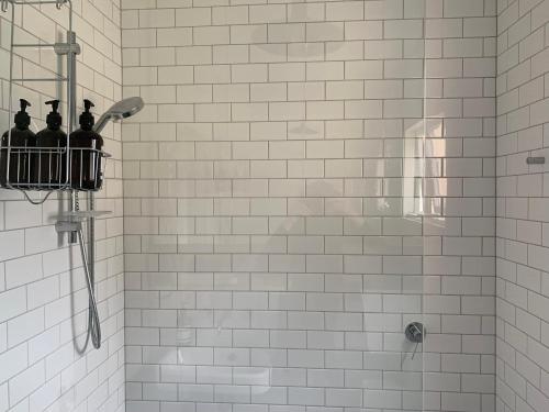 a bathroom with a shower with bottles in a basket at Light filled terrace flat in Sydney