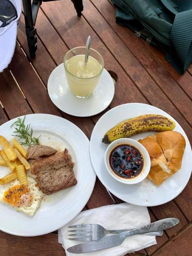 two white plates of food with meat and a banana at Smiling Pine Dalat in Ấp Man Ling