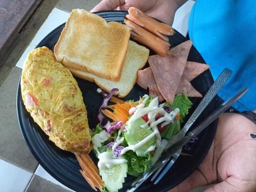 a plate of food with toast and a salad and a sandwich at Villa Allure Koh Mak in Ko Mak