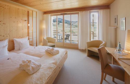 - une chambre avec un lit, un bureau et une fenêtre dans l'établissement Natur & Wellnesshotel Breggers Schwanen - Bernau im Schwarzwald, à Bernau im Schwarzwald