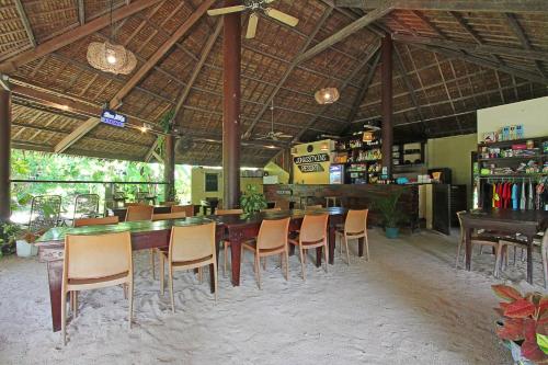 a restaurant with a long table and chairs in it at Jonas and Twins Resort in General Luna