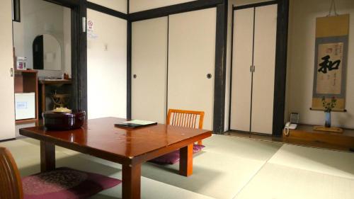 a dining room with a wooden table and cabinets at 白水温泉竹の倉山荘 in Minami Aso