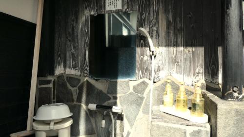 a bathroom with a sink and a toilet at 白水温泉竹の倉山荘 in Minami Aso