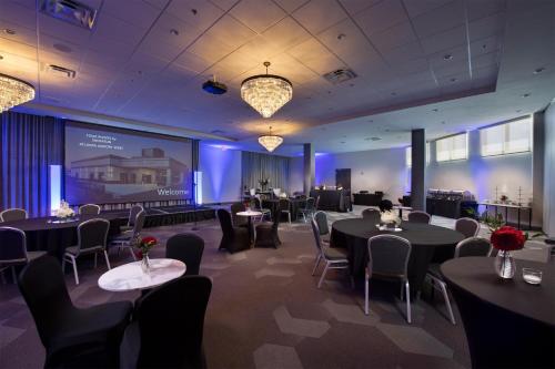 a banquet room with tables and chairs and a screen at Four Points by Sheraton Atlanta Airport West in Atlanta