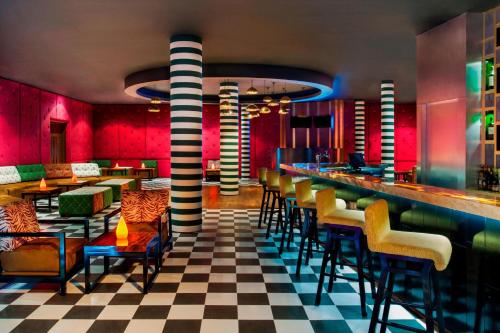 a restaurant with a bar with chairs and tables at Le Meridien Bali Jimbaran in Jimbaran