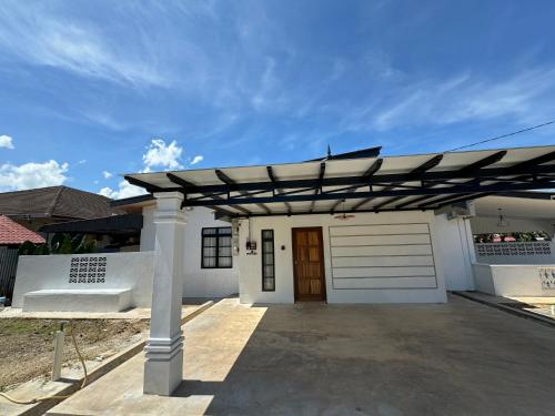 a white garage with a pergola on top of it at Kuala Berang-Rumah Jambu Manis-NETFLIX,FREE WIFI in Kuala Berang