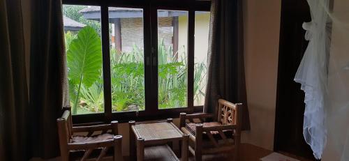 a room with a table and two chairs and a window at Jonas and Twins Resort in General Luna