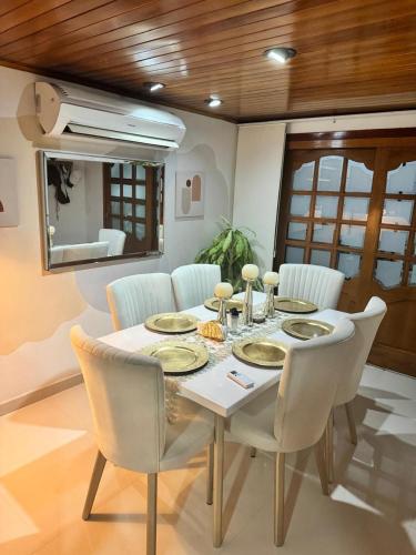 a dining room with a table with white chairs and a tableablish at Casa central popa in Cartagena de Indias