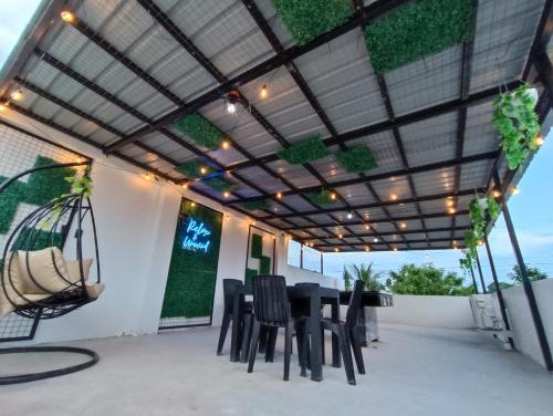 a patio with a table and chairs under a pergola at A's Hideaway Pampanga in Guagua