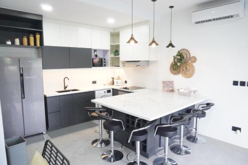 a kitchen with a white counter and stools at A's Hideaway Pampanga in Guagua