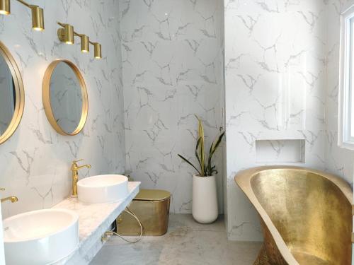 a bathroom with two sinks and a tub at Villa Emas Mulia Uluwatu luxury 2 in Uluwatu