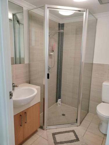a bathroom with a shower and a sink and a toilet at Studio close to Airport, City & Esplanade in Cairns North