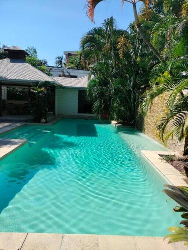 a large blue swimming pool in front of a house at Studio close to Airport, City & Esplanade in Cairns North
