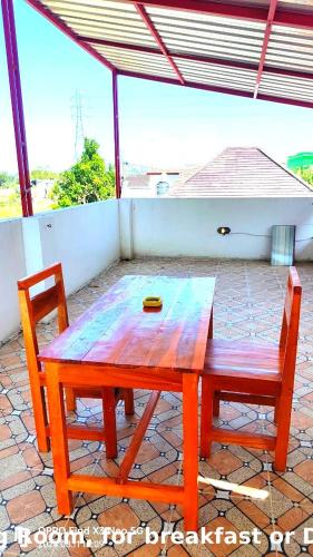a wooden table and a chair on a patio at Jatisela homestay in Midang