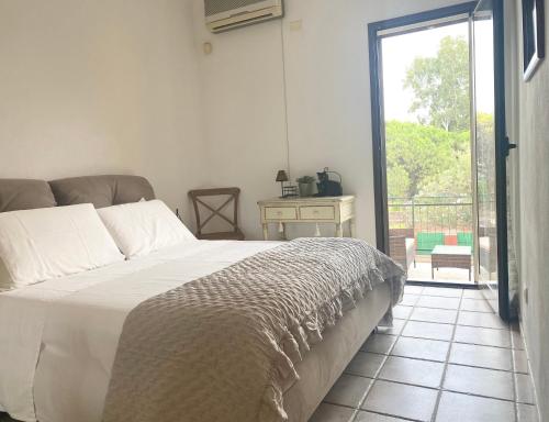 a bedroom with a bed and a sliding glass door at Casa Robi in Flumini di Quartu