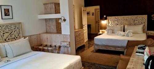 a hotel room with two beds and a table at Ru Boutique in Kandy