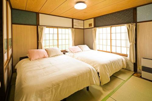 網走市にあるCottage Abashiriの窓が2つある部屋にベッドが2つある