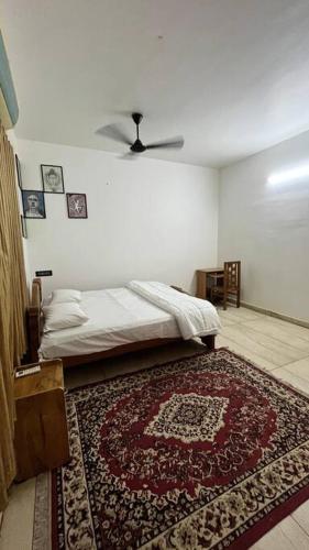a bedroom with a bed and a rug on the floor at Traditional house near Kochi in Cochin