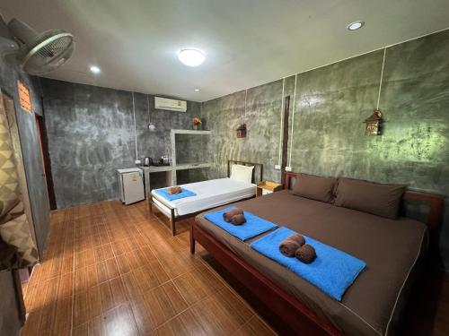 a bedroom with a bed with two teddy bears on it at Pim Bungalow in Mae Haad