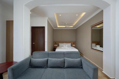 a bedroom with a bed and a blue couch at Tea Garden Riverside in Munnar