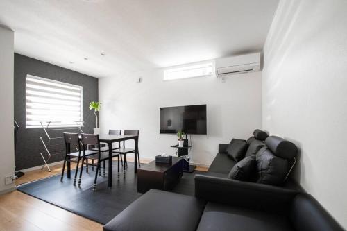 a living room with a black couch and a table at Apollo in Hakodate