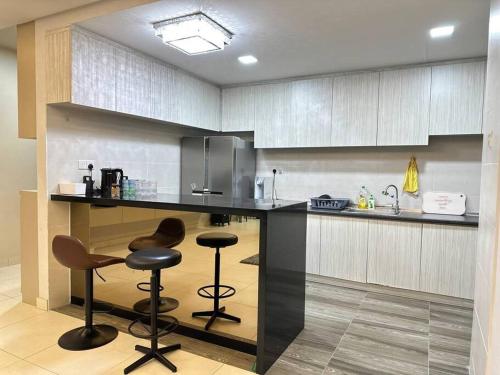 クチンにあるJazz Suite at Vivacity megamall 3 Bed 2 Bathのキッチン(カウンター、バースツール2つ付)