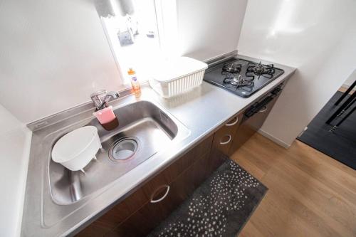 a kitchen with a sink and a stove at Apollo in Hakodate