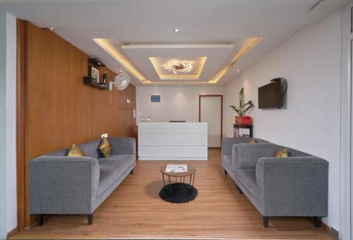 a living room with two couches and a tv at Tea Garden Riverside in Munnar