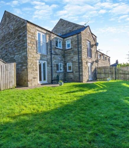 a large brick house with a grass yard at Ingledale Apartment, Ingleton, Yorkshire Dales National Park, Famous Three Peaks, Near The Lake District, Pets Are Welcome in Ingleton 