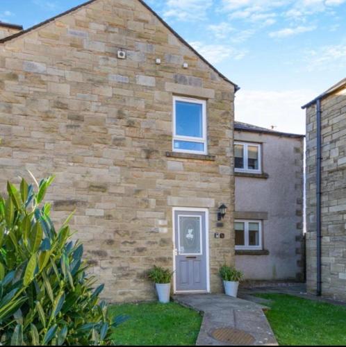 a brick house with a door on the side of it at Ingledale Apartment, Ingleton, Yorkshire Dales National Park, Famous Three Peaks, Near The Lake District, Pets Are Welcome in Ingleton 