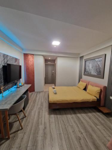 a room with a bed and a desk and a television at Vanilla Boutique Hotel in Skopje