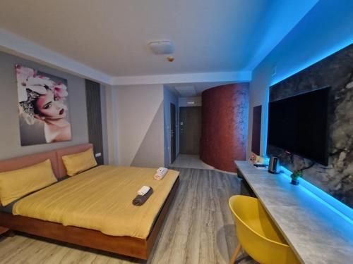 a bedroom with a bed and a desk and a television at Vanilla Boutique Hotel in Skopje