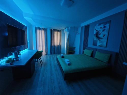 a blue room with a bed and a desk at Vanilla Boutique Hotel in Skopje