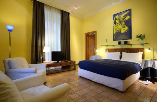 a bedroom with a bed and a couch and a chair at Hotel Locanda Cairoli in Rome