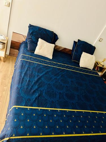 - un grand lit bleu avec des draps et des oreillers bleus dans l'établissement Villa les cèdres piscine nature, à Fabrègues