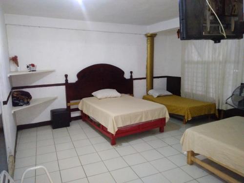 a bedroom with two beds and a tv in it at Hotel Casa Ortiz in Zorita