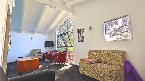 a living room with a chair and a table at Waiheke Backpackers Hostel in Onetangi