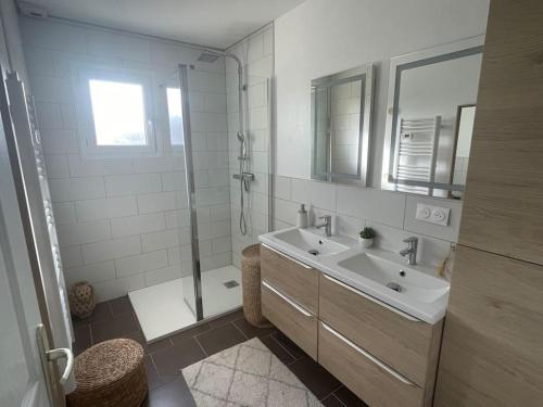une salle de bain blanche avec un lavabo et une douche dans l'établissement Maison familiale, emplacement idéal, à Aigneville