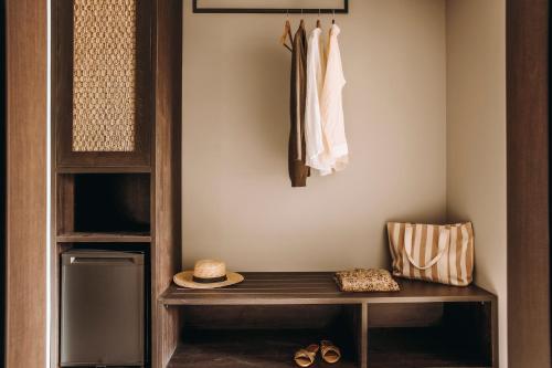 a closet with a wooden bench in a room at Cook's Club Ialysos Rhodes in Ialyssos