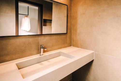 a bathroom with a sink and a mirror at Cook's Club Ialysos Rhodes in Ialyssos