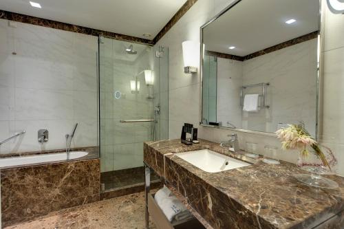 a bathroom with a sink, toilet and tub at Meliá Genova in Genoa