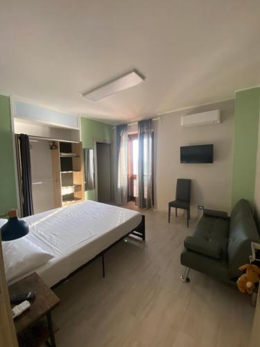 una camera da letto con un letto grande e una sedia di La terrazza nel borgo a Tortora