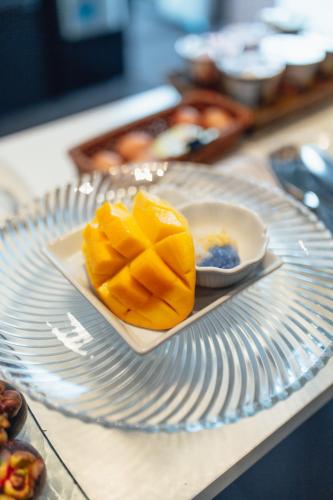 a plate with a piece of fruit on a table at NANEE Phra Singh in Chiang Mai
